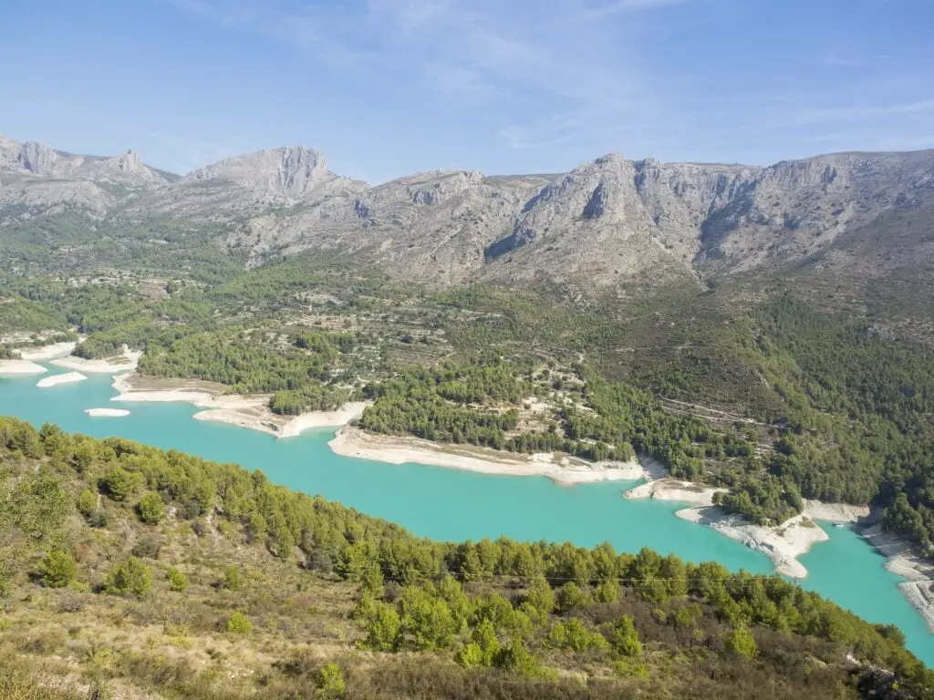 Embalse de Guadalest surrounded by hills covered in greenery under the sunlight in Spain