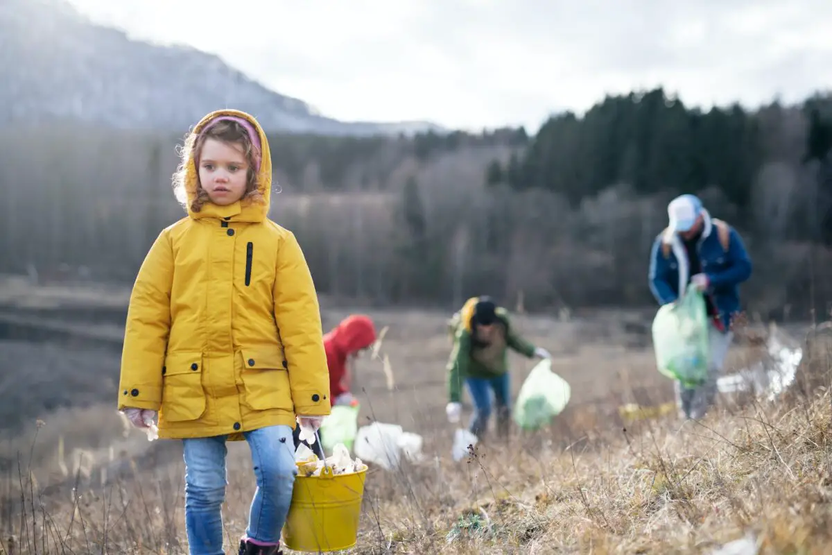 Group of activists picking up litter in nature, environmental pollution concept