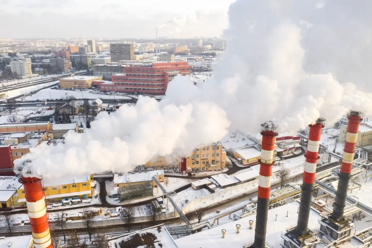 In the winter city, the factory's chimneys are smoking. The concept of air pollution